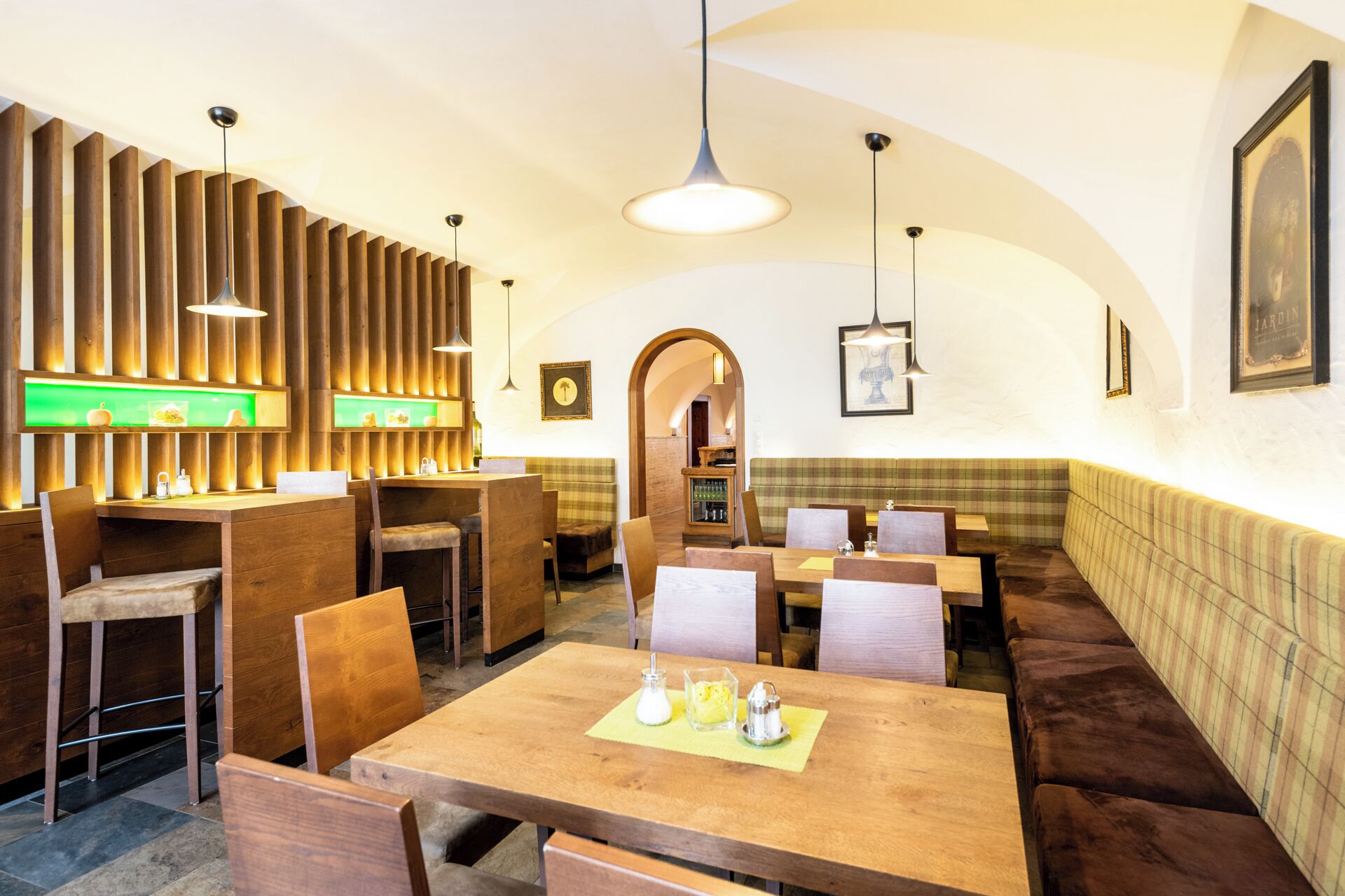 Ein Restaurantinnenraum mit Holzwänden, Tischen und Sitzecken.