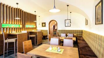 Ein Restaurantinnenraum mit Holzwänden, Tischen und Sitzecken.