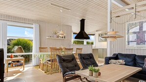 A spacious living area with a wooden table, two black leather chairs, a blue sofa, and a white furry rug. - "Tjarven" - 350m from the sea by Interhome (Hejls)