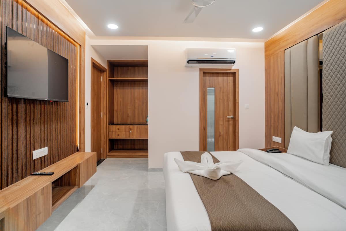 Une chambre d’hôtel équipée d’un lit, d’un téléviseur fixé au mur, d’une armoire et d’un appareil de climatisation.
