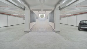 A clean, modern indoor space with a central corridor, white walls, and a grey floor. - Hotel SK Elite (Jodhpur)