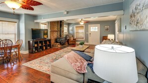 A living room with a fireplace, a television, a sofa, and a dining area with chairs. - Route 66 Retreat: Dog-Friendly Home in Williams (Williams)