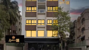 A modern hotel with a flat facade, multiple balconies, and a sign indicating it is 'Lance 21'. - Lance 21 Premium Serviced Apartments (Chennai)