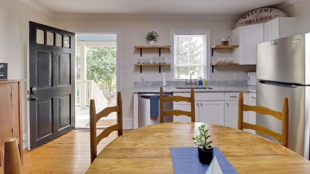 A kitchen with a wooden table, chairs, a refrigerator, and a 'Welcome Friends' sign. - Steps to Downtown! Family Home in Historic Edenton (Edenton)