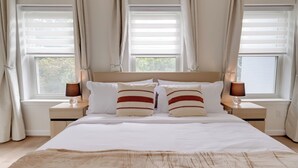 A bedroom with a large bed, two bedside tables, and a window with curtains. - Central DC Location! Urban Oasis in Logan Circle (Washington)