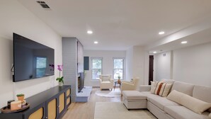 A modern living room with a flat-screen TV, a sofa, a coffee table, and a fireplace. - Central DC Location! Urban Oasis in Logan Circle (Washington)