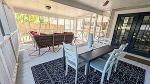 A covered patio with a dining table and chairs, a ceiling fan, and a view of the backyard. - Charming Lux Gem in Med Center w/ 2 K Beds-Patio-Backyard! (Houston)