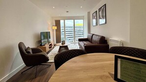 A modern living room with a wooden coffee table, leather sofas, and a television.