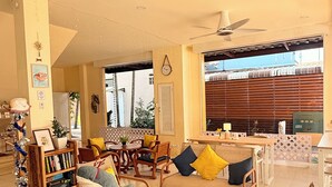 A spacious living area with a sofa set, a coffee table, and a bookshelf. - Kata Kata Stay (Karon)