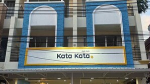 A building with a sign reading "Kata Kata" and a reception area with a desk and chairs. - Kata Kata Stay (Karon)