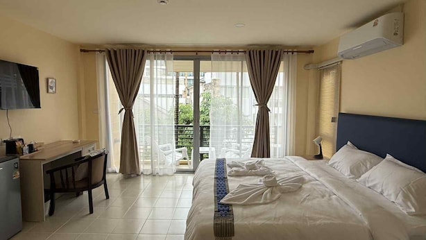A hotel room with a bed, a desk, a chair, and a TV. - Kata Kata Stay (Karon)