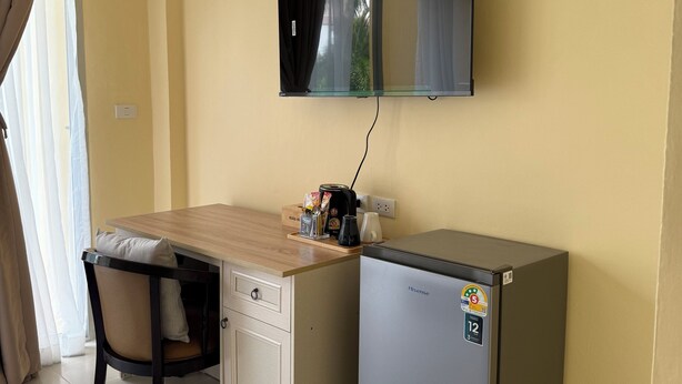 A compact kitchenette with a wooden countertop, a refrigerator, a microwave, and a small cabinet. - Kata Kata Stay (Karon)