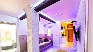 Un intérieur moderne comprenant une cuisine, un coin repas et un espace de vie, avec une porte-fenêtre coulissante donnant sur un jardin.