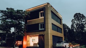 A two-story building with a ground-level entrance and a visible window on the second floor. - ZAAD SUITE (Meenachil)