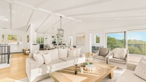A spacious living area with a large sofa, a coffee table, and a balcony with a view. - Vineyard Views w/ Pool & Game Room Near Trails | Beginnings Ranch & Vineyard (Paso Robles)