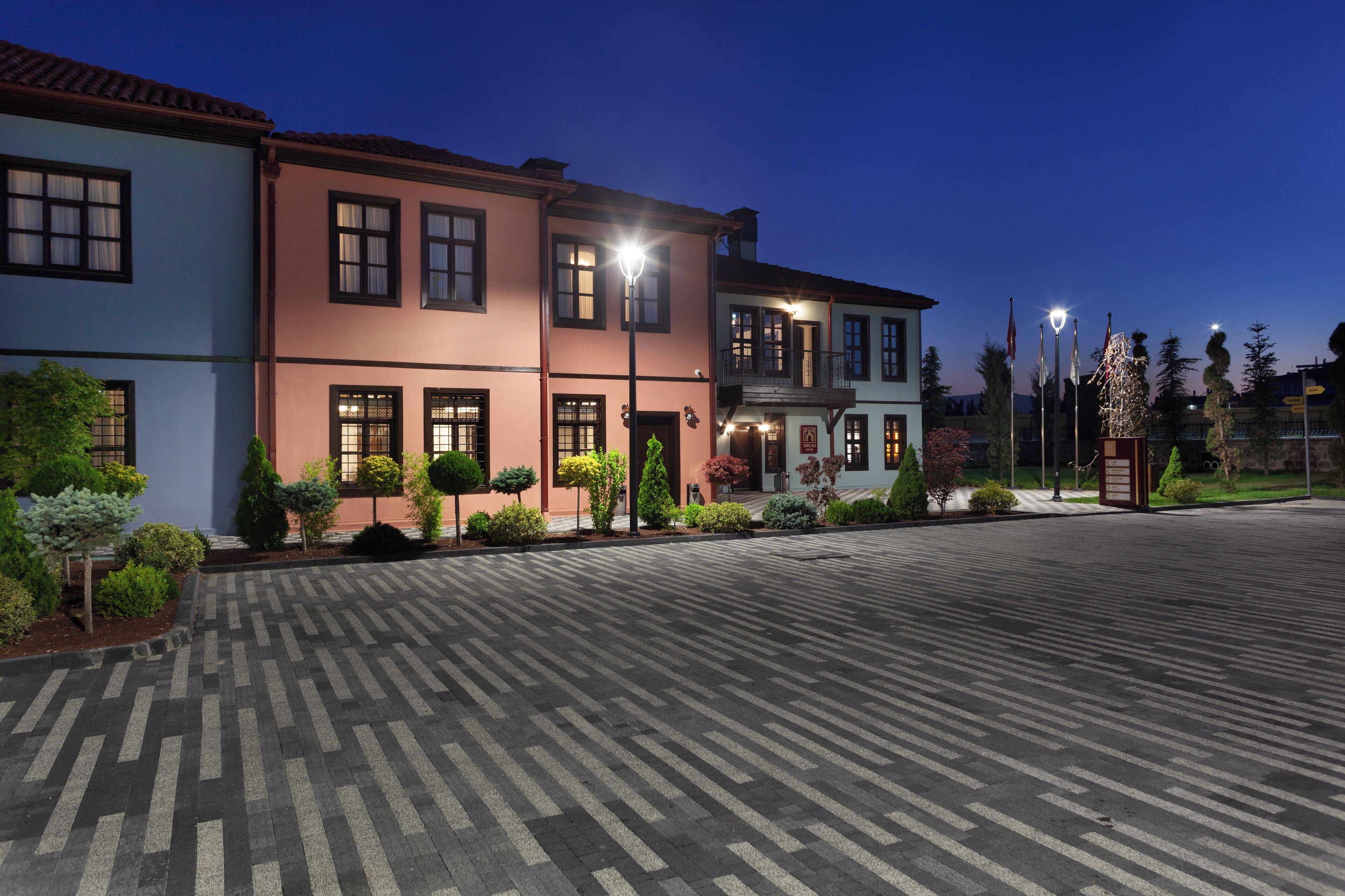 A hotel with a paved courtyard, multiple buildings, and a Christmas tree.