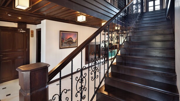 A multi-level wooden staircase with wrought iron railings and pendant lighting. - SIRÇALI HOTEL (Konya)