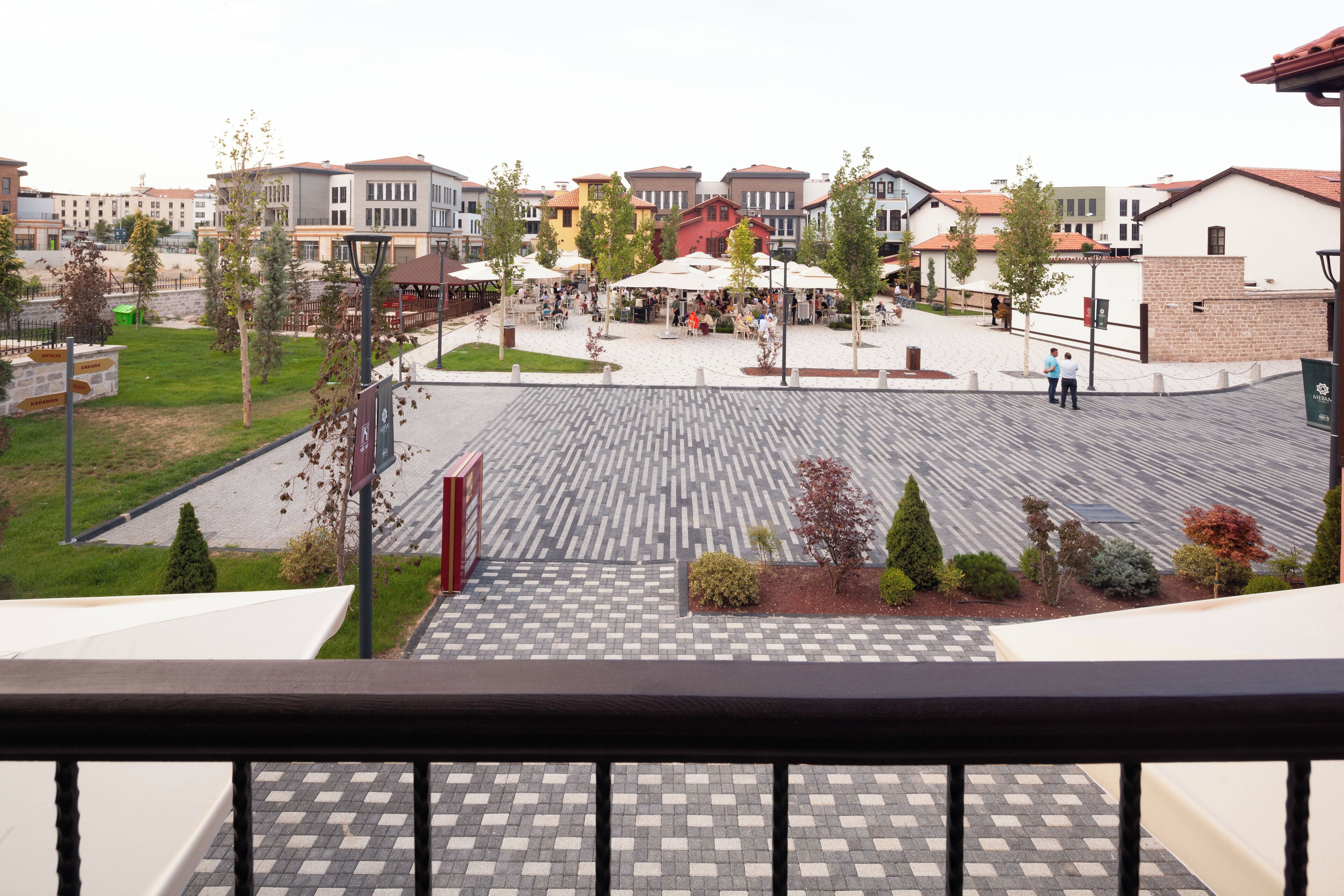 A courtyard with outdoor seating, surrounded by multi-story buildings with varied architectural styles.