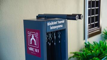 Un kiosque d’information bleu, portant l’inscription « SIRCAI HOTEL » et, au-dessus, une autre inscription indiquant « Station de réparation de vélos ».