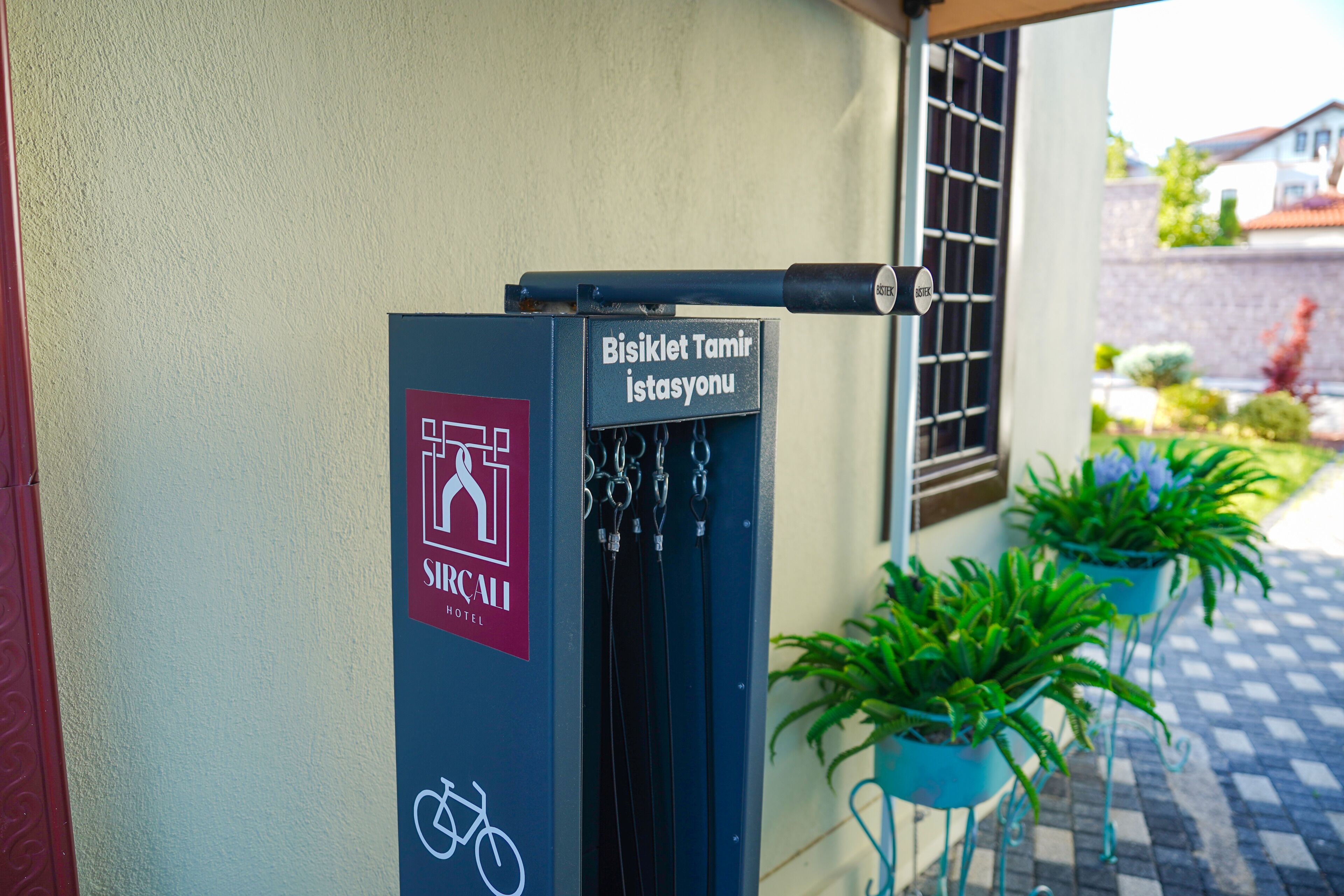 A bicycle parking station with a sign for the Sincali Hotel.