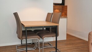 Ein Essbereich mit einem Holztisch und vier braunen Stühlen mit Metallgestellen.