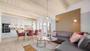 A modern kitchen with white cabinets, a built-in oven, and a patterned backsplash. - Vacation home Marga Sophie- dreamlike idyll under thatch in Dagebüll (Dagebüll)