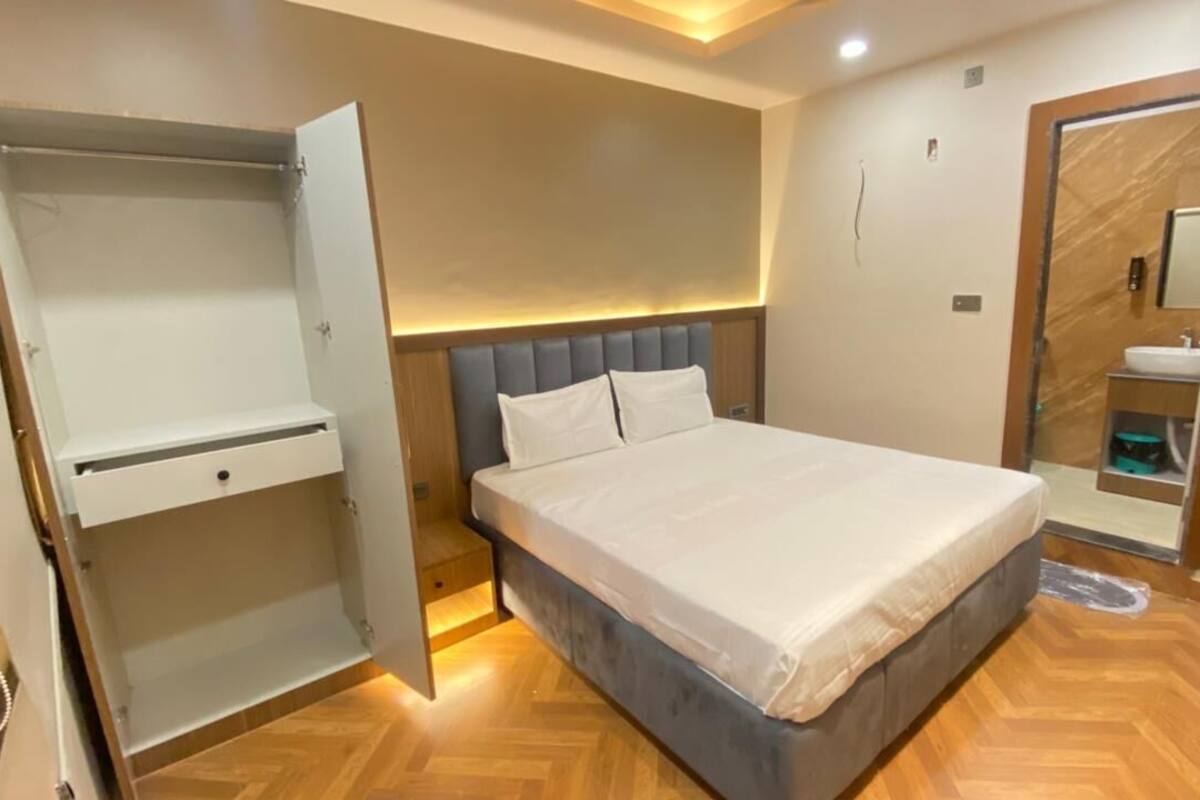 A bedroom with a bed, a wardrobe, and a mirror.