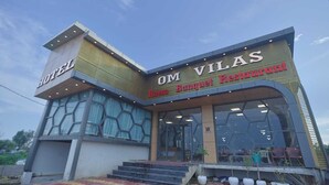 A hotel with a modern design, featuring a prominent sign for 'OM VILAS Banquet Restaurant' and a visible entrance with steps leading up to it. - Hotel Om Vilas (Mathura)