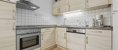 A modern kitchen with a built-in oven, a microwave, and a coffee maker.
