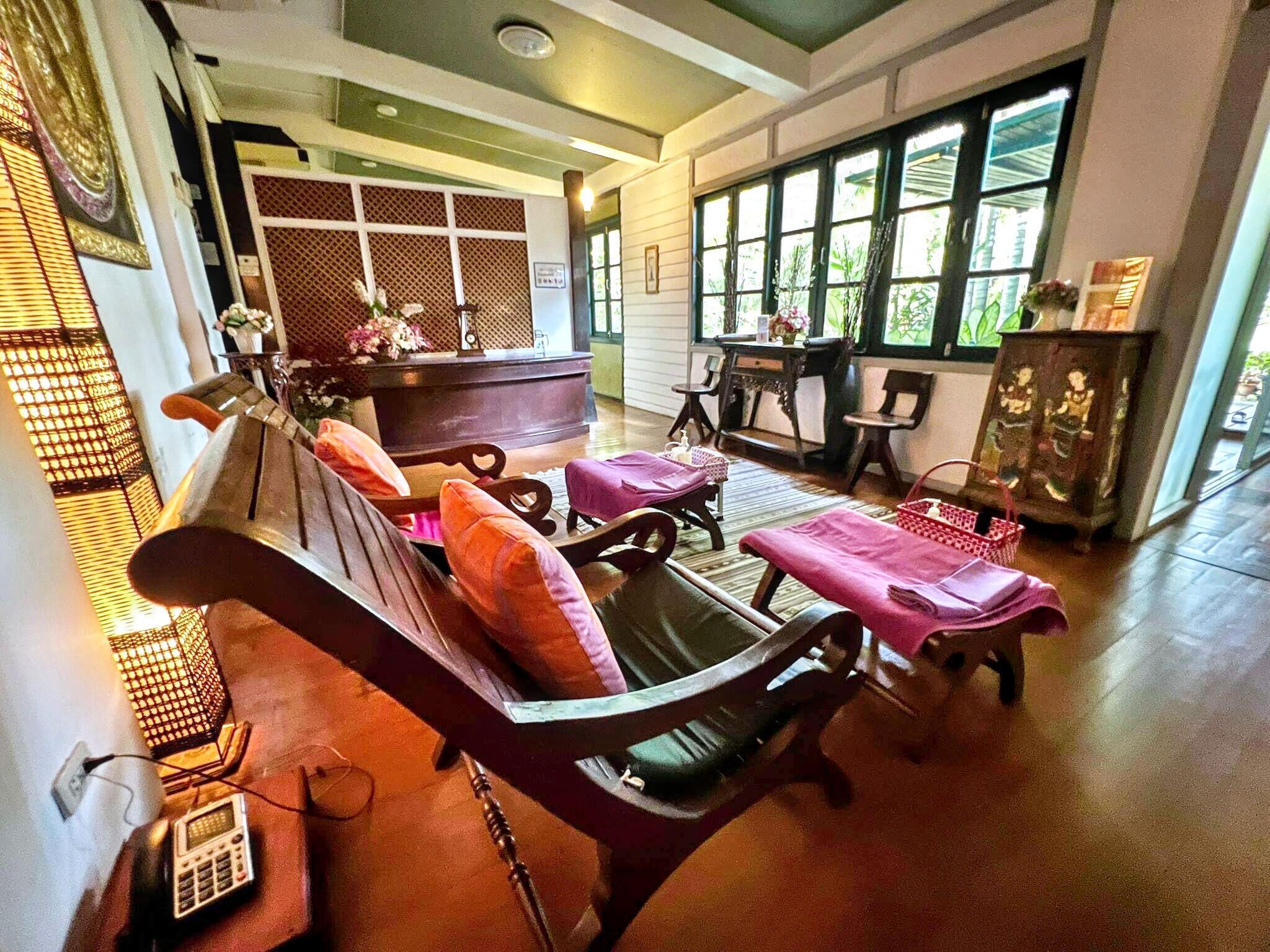 A traditional room with a sofa, chairs, a table, and a cabinet.