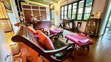 A traditional room with a sofa, chairs, a table, and a cabinet.