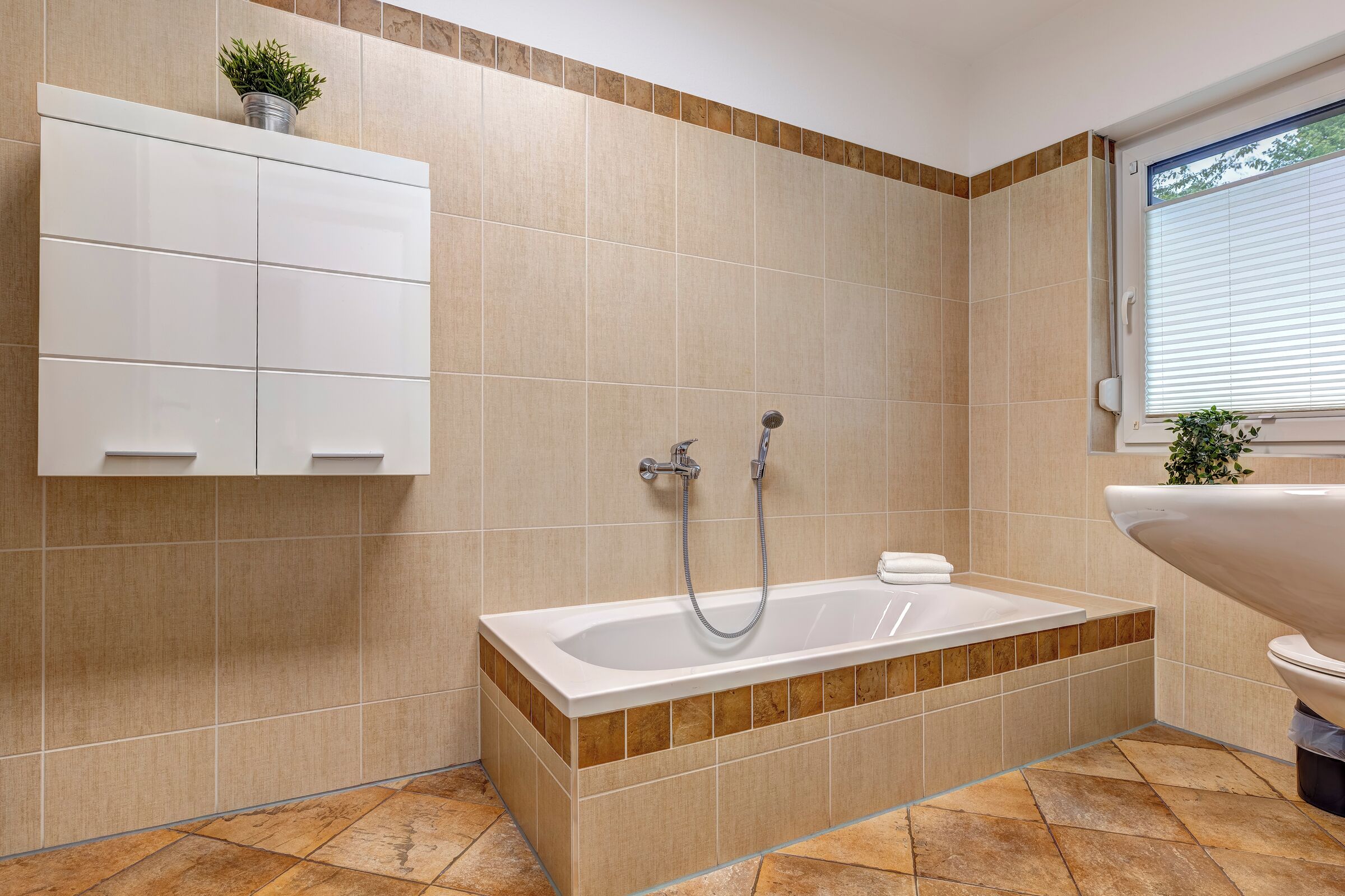 Un bagno moderno con una vasca da bagno indipendente, un water e un lavandino.