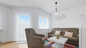 A modern living room with a sofa, armchair, and coffee table.