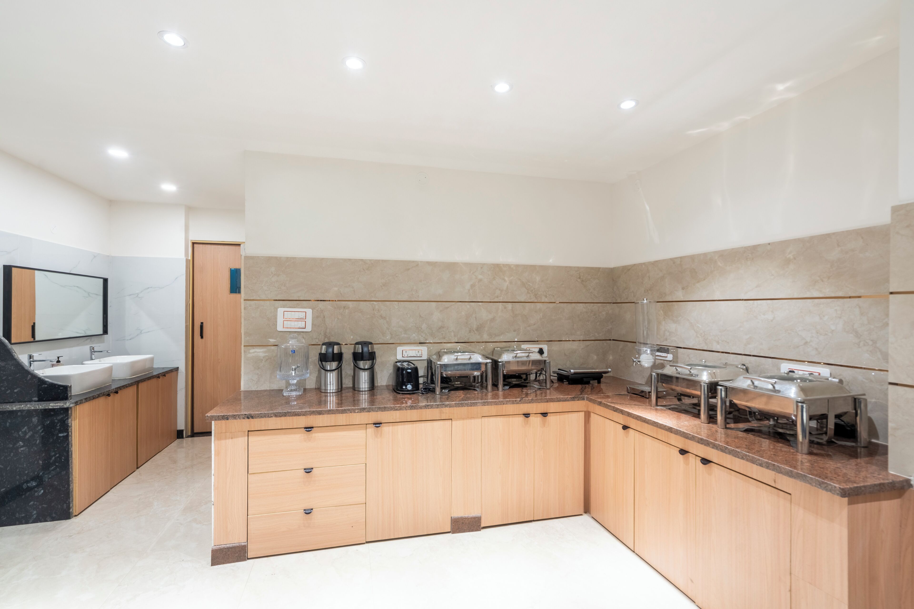 A modern kitchen with a granite countertop, wooden cabinets, and built-in appliances including a coffee maker, toaster, and microwave.
