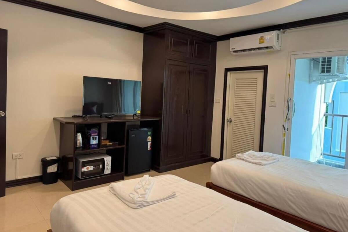 Quarto de hotel com duas camas, televisão, minibar e ar condicionado.
