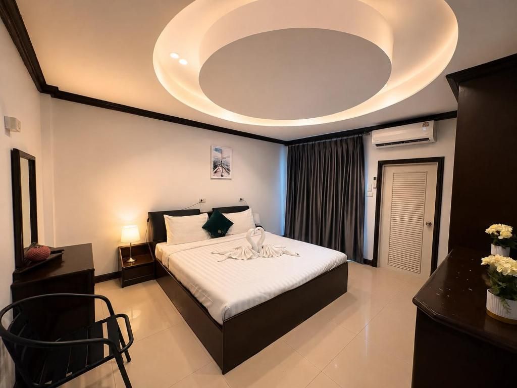 Una habitación de hotel moderna con una cama grande, un escritorio y una silla.