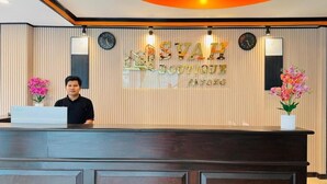 Un mostrador de recepción con un letrero que dice "STAFF BOUTIQUE" y dos relojes encima.