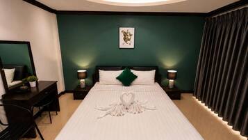 A hotel room with a bed, bedside tables, a desk, and a chair.
