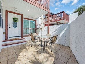 Ein Haus mit Haustür, Balkon und Terrasse, komplett mit Tisch und Stühlen.