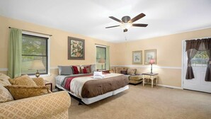 A bedroom with a bed, a chair, a table, and a ceiling fan. - Nature's Sanctuary-3 Mi to Downtown Eureka Springs (Eureka Springs)