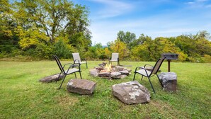 A fire pit with four chairs arranged around it in a grassy outdoor area. - Nature's Sanctuary-3 Mi to Downtown Eureka Springs (Eureka Springs)