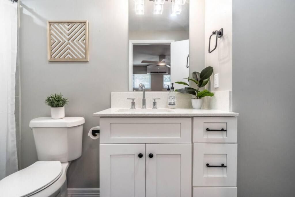 A modern bathroom with a toilet, sink, and cabinets.