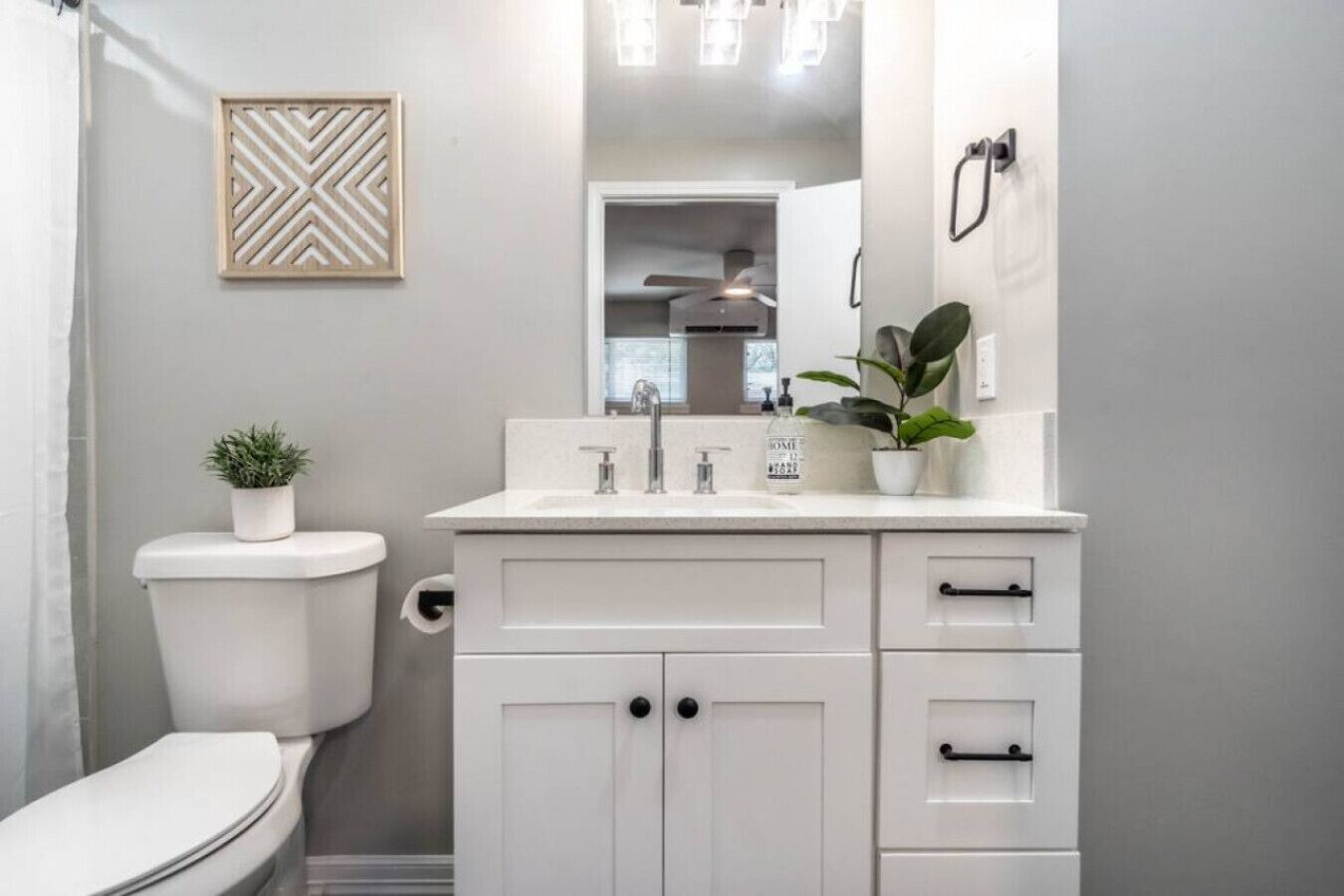 A modern bathroom with a toilet, sink, and cabinets.