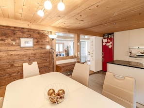 A wooden interior with a dining table, chairs, a red refrigerator, and a kitchen area. - Mys Chalet - Authentic & renovated (Jaun)