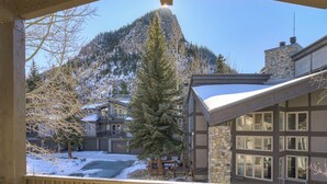 A mountain cabin with a stone facade, large windows, and a view of a snowy mountain. - Pet Friendly Studio Cross Creek Condo - CC102A (Frisco)