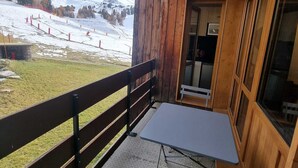 A wooden cabin with a balcony overlooking a snowy mountain landscape. - Renovated Studio for 4 in Plagne Bellecôte, balcony (Plagne Bellecôte)