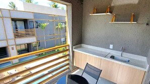 Une cuisine moderne dotée d’un évier encastré, de meubles en bois et d’un petit coin repas avec une table et des chaises.