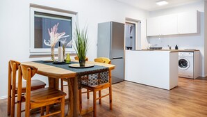 Ett kompakt kök med matplats, tvättmaskin och ett fönster med utsikt.