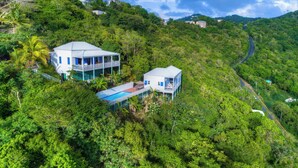 A two-story house with a balcony, surrounded by lush greenery and a winding road. - NEW LISTING: Makere House, Cottage & Pool - Spectacular Views, 5 Mins To Beaches (Cane Garden Bay)