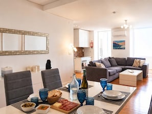 Un salon moderne comprenant un coin repas, une cuisine et une grande fenêtre.